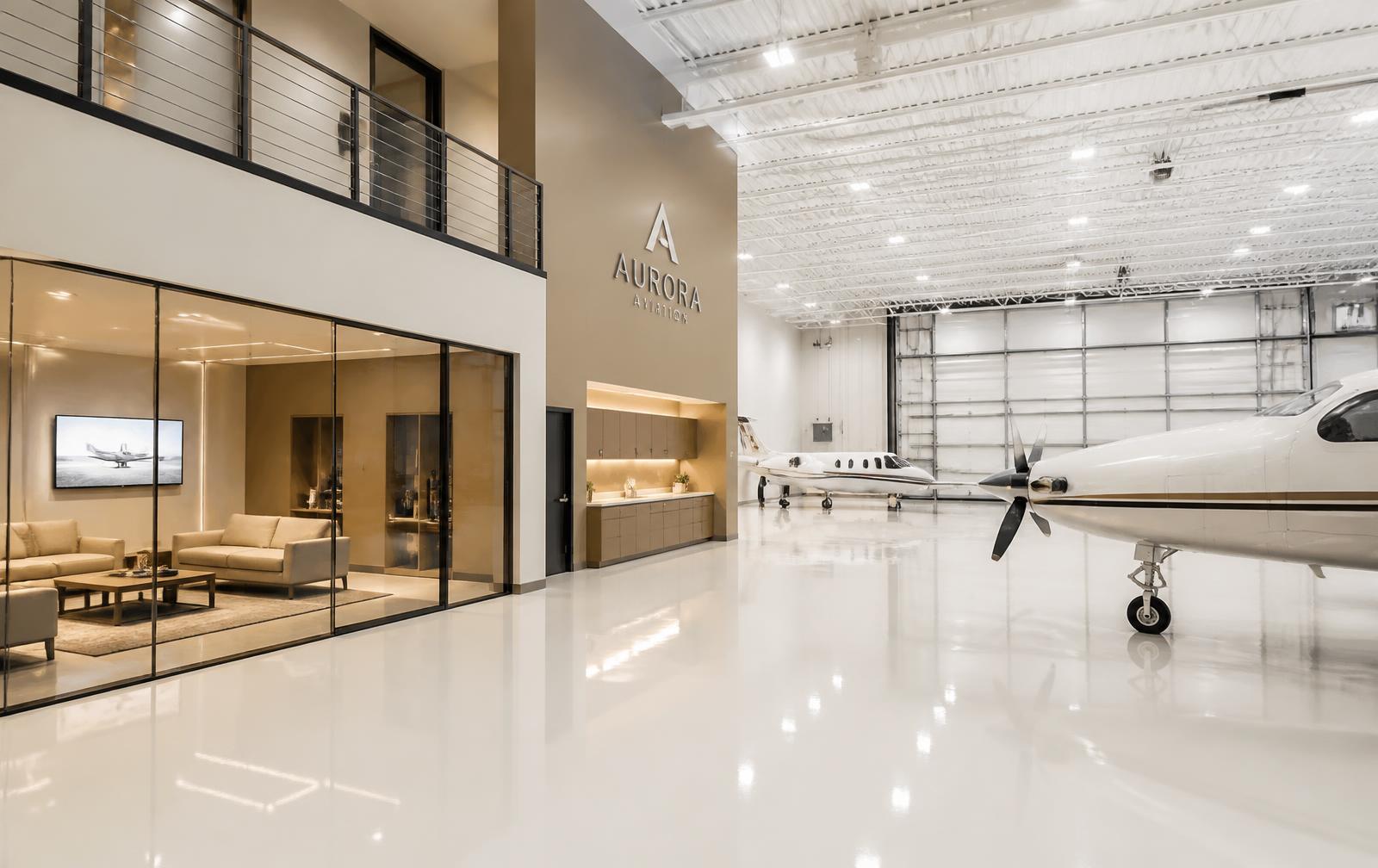 Bright modern hangar interior with polished epoxy floor, LED lighting, and a glass-walled crew lounge